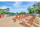 A sprawling pool deck featuring numerous lounge chairs, mature landscaping, and a refreshing swimming pool at 11723 Boynton Ln # 1, New Port Richey, FL 34654