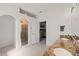 Bright bathroom featuring double sinks with granite countertop, and glass enclosed shower, leading to a bedroom at 11831 Thicket Wood Dr, Riverview, FL 33579