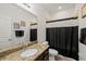 Well-lit bathroom features a granite vanity, a white toilet, and a shower with a black and white curtain at 11831 Thicket Wood Dr, Riverview, FL 33579