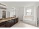 Bright bathroom featuring double vanity, soaking tub, and large windows at 11831 Thicket Wood Dr, Riverview, FL 33579