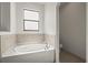 Corner bathtub featuring tile surround, and a window at 11831 Thicket Wood Dr, Riverview, FL 33579