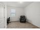 Neutral bedroom features a black leather chair next to a window, perfect for relaxing and reading at 11831 Thicket Wood Dr, Riverview, FL 33579