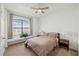 Cozy bedroom with a window seat, ceiling fan, neutral-colored walls, and plush carpeting at 11831 Thicket Wood Dr, Riverview, FL 33579