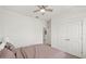 Bright bedroom featuring a ceiling fan, neutral walls, plush carpeting, and a double-door closet at 11831 Thicket Wood Dr, Riverview, FL 33579