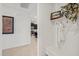 Hallway with coat rack and a shelf with decor leads to the kitchen with stainless steel appliances at 11831 Thicket Wood Dr, Riverview, FL 33579