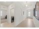 Bright hallway with ceramic tile and recessed lights leads to the laundry room and the home's entrance at 11831 Thicket Wood Dr, Riverview, FL 33579