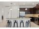 Kitchen island featuring pendant lights and dark cabinets with seating offers an excellent workspace at 11831 Thicket Wood Dr, Riverview, FL 33579
