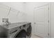 A well-equipped laundry room is showcased, featuring a modern washer and dryer set and wire shelving at 11831 Thicket Wood Dr, Riverview, FL 33579