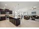 Open kitchen and living space with dark cabinetry, granite countertops, and stainless steel appliances at 11831 Thicket Wood Dr, Riverview, FL 33579