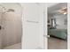 Walk-in shower featuring a rainfall shower head, as well as traditional shower head, leading to a bedroom at 11831 Thicket Wood Dr, Riverview, FL 33579