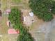 Top-down aerial view showing multiple structures with red roofs among trees, including main house and outbuildings on property at 1202 Williams Rd, Plant City, FL 33565