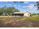 Exterior of home featuring an enclosed screened porch, lush lawn and mature landscaping at 1202 Williams Rd, Plant City, FL 33565