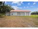 Large metal barn with multiple garage doors and a red roof, surrounded by a grassy field at 1202 Williams Rd, Plant City, FL 33565