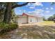 Three-car garage featuring a red roof, located in a large, tree-lined yard at 1202 Williams Rd, Plant City, FL 33565