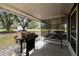 View of the outside from the screened-in porch with a grill and outdoor bench at 1202 Williams Rd, Plant City, FL 33565