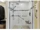 Modern shower with glass enclosure, tiled walls, stone floor, bench, and grab bar at 1202 Williams Rd, Plant City, FL 33565