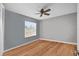 Clean bedroom with hardwood floors, gray walls, and a ceiling fan with windows at 12493 Fish Cove Dr, Spring Hill, FL 34609