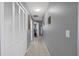 Hallway with closet doors on the left and neutral tile flooring at 12493 Fish Cove Dr, Spring Hill, FL 34609