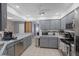 An open, bright kitchen featuring gray cabinets and a view of the bar seating area at 12493 Fish Cove Dr, Spring Hill, FL 34609