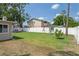 Large fenced backyard with a playset, green grass, and ample space for outdoor activities and entertaining at 12606 Rain Forest St, Temple Terrace, FL 33617