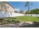 Large backyard with a playset and green grass, surrounded by a white fence and mature landscaping at 12606 Rain Forest St, Temple Terrace, FL 33617