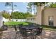 Paver patio with a metal dining table and chair set in a fenced yard with a playset and mature landscaping at 12606 Rain Forest St, Temple Terrace, FL 33617