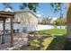 Paver patio in fenced backyard featuring a dining table and chairs set, a built-in grill, and mature landscaping at 12606 Rain Forest St, Temple Terrace, FL 33617