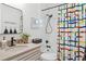 Stylish bathroom with a colorful shower curtain, updated fixtures, and a modern mirror at 12606 Rain Forest St, Temple Terrace, FL 33617