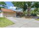 Well-kept single-story home featuring an attached garage and mature trees at 12606 Rain Forest St, Temple Terrace, FL 33617