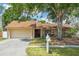 Charming single-story home featuring a well-maintained lawn and mature trees at 12606 Rain Forest St, Temple Terrace, FL 33617