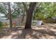 View of the backyard with playset, mature trees, fenced yard, and exterior building at 1310 Hilton Pl, Tampa, FL 33604