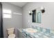 A well-lit bathroom featuring a classic blue and white tiled countertop, a neutral sink, and a coordinated toilet area at 1310 Hilton Pl, Tampa, FL 33604