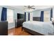 Spacious bedroom features hardwood floors, large windows with dark blue curtains, and modern furniture at 1310 Hilton Pl, Tampa, FL 33604