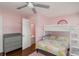 A charming bedroom with a bunk bed and a colorful quilt, accented by pastel pink walls and a rainbow wall decal at 1310 Hilton Pl, Tampa, FL 33604