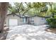 Spacious driveway leading to a single-car garage, surrounded by lush greenery at 1310 Hilton Pl, Tampa, FL 33604