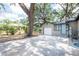 Home exterior featuring large trees, a driveway, and an attached garage at 1310 Hilton Pl, Tampa, FL 33604