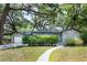 Charming single-story home with a well-manicured lawn and mature shade trees at 1310 Hilton Pl, Tampa, FL 33604