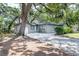 Home exterior with driveway, landscaping, mature trees and light blue front door at 1310 Hilton Pl, Tampa, FL 33604