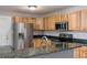 Modern kitchen with stainless steel appliances, light wood cabinets and granite countertop at 1310 Hilton Pl, Tampa, FL 33604