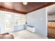 Sunroom with wood ceiling, white storage bench, and entrance to the kitchen at 1310 Hilton Pl, Tampa, FL 33604
