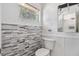 Charming bathroom featuring stylish wall tile, toilet, and fixtures at 1341 Sandy Ln, Clearwater, FL 33755