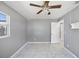 Bright bedroom space with a ceiling fan, large window, and an open doorway at 1341 Sandy Ln, Clearwater, FL 33755
