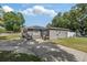Side view of house, showcasing mature trees, good lawn maintenance and access to driveway at 1341 Sandy Ln, Clearwater, FL 33755
