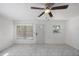 Light-filled living room with a ceiling fan, large windows, and a front door with a decorative window at 1341 Sandy Ln, Clearwater, FL 33755
