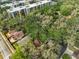 Aerial view featuring the residence nestled among green trees near modern apartment buildings at 13703 Sweetwater Cove Pl, Tampa, FL 33613