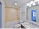 Bright bathroom featuring a tiled shower-tub combo and vanity with granite countertop at 13703 Sweetwater Cove Pl, Tampa, FL 33613