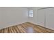 Bright bedroom featuring a window, wood floors, and a closet with bi-fold doors at 13703 Sweetwater Cove Pl, Tampa, FL 33613