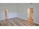 Bright bedroom featuring wood-look flooring and two entryways, creating an open and inviting space at 13703 Sweetwater Cove Pl, Tampa, FL 33613