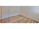 A bright bedroom featuring wood-look flooring with a white door offering access to other areas of the home at 13703 Sweetwater Cove Pl, Tampa, FL 33613