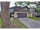 Two story home with a dark brown garage door, beige walls, and dark brown siding at 13703 Sweetwater Cove Pl, Tampa, FL 33613
